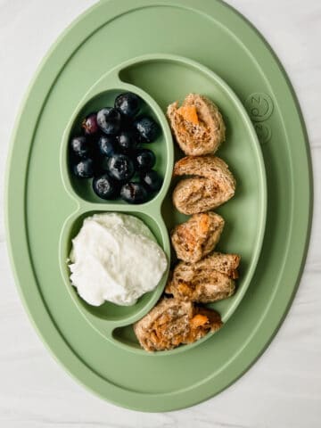 This is a photo of a baby led weaning meal with a tahini chia jam pinwheels, yogurt and blueberries