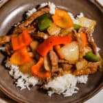 Close up of pepper steak stir fry served over rice.