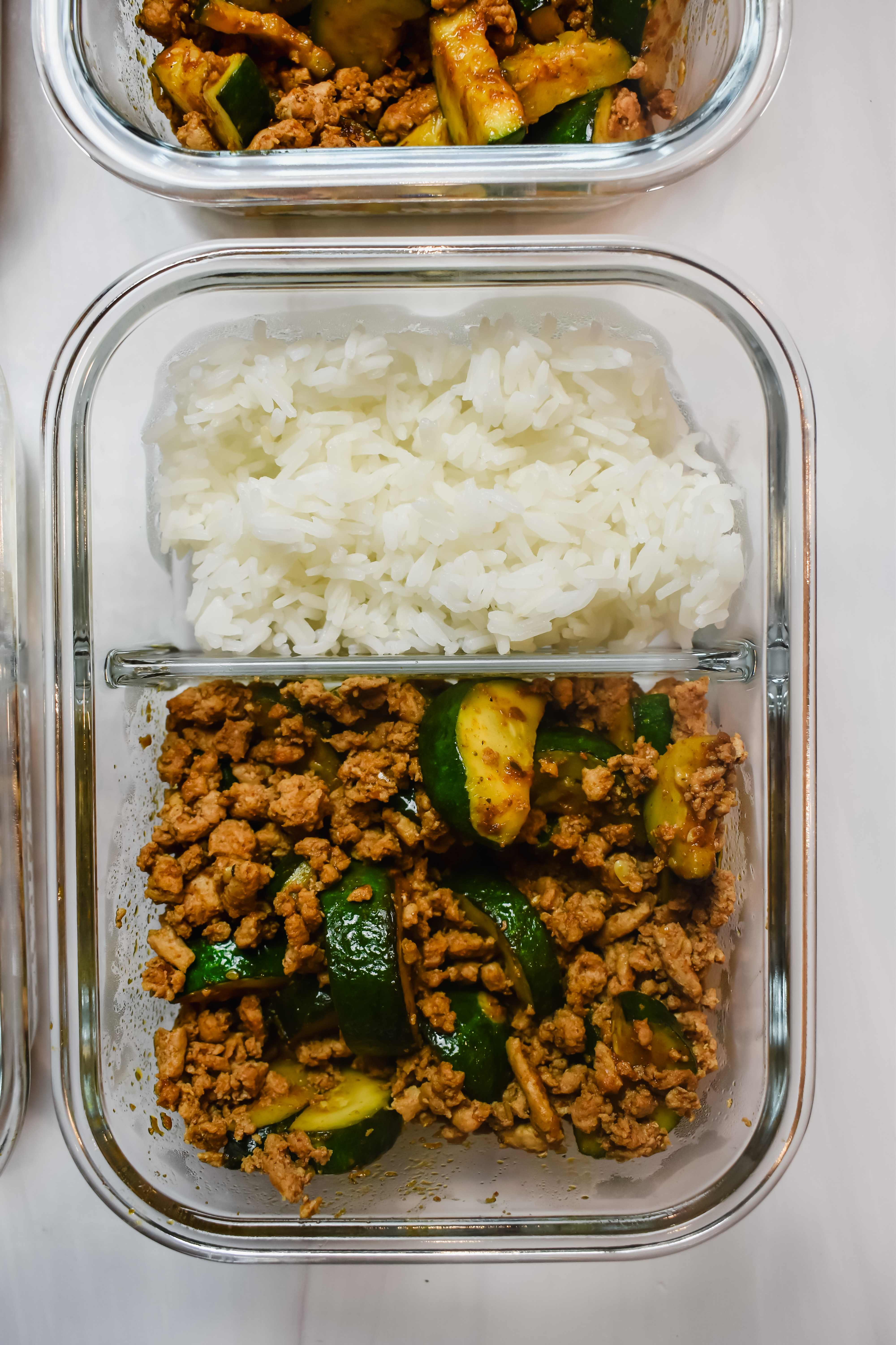 This is a photo of my ground turkey and zucchini meal prep in a glass 2 compartment container. This is a top view.